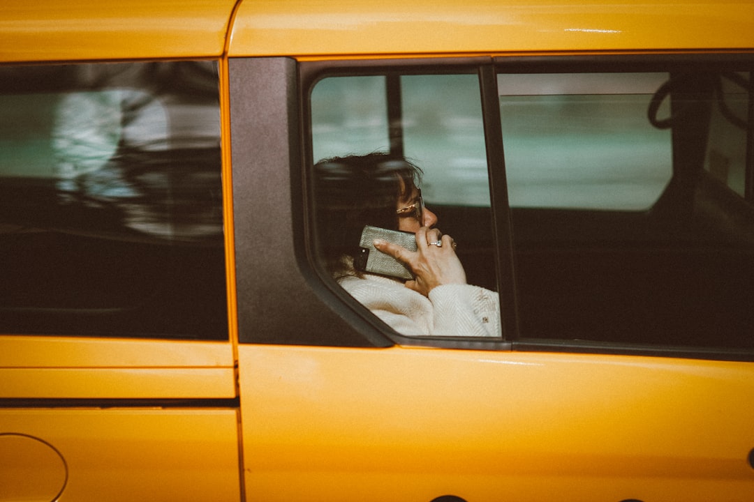 woman in white long sleeve shirt sitting on yellow car