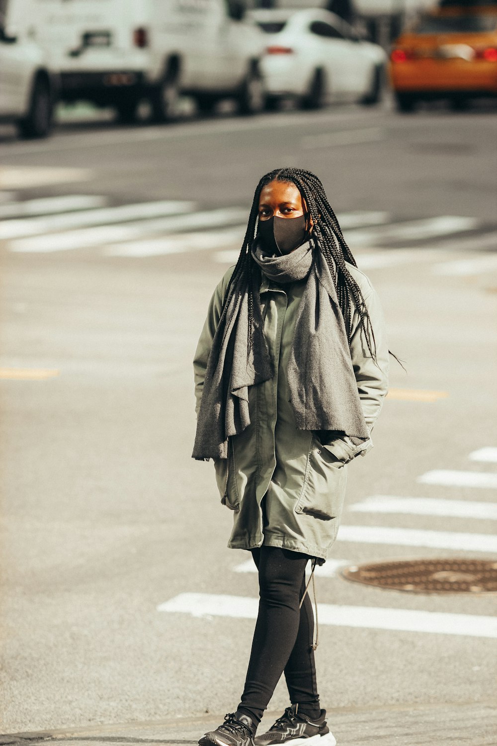 woman in gray coat standing on road during daytime
