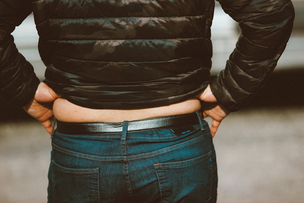 Femme en veste en cuir noir et jean en jean bleu