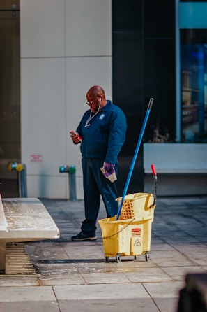 man in blue suit holding yellow plastic basket