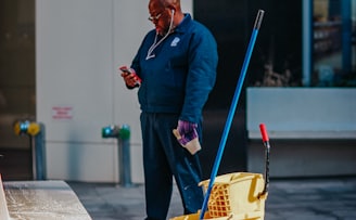 man in blue suit holding yellow plastic basket