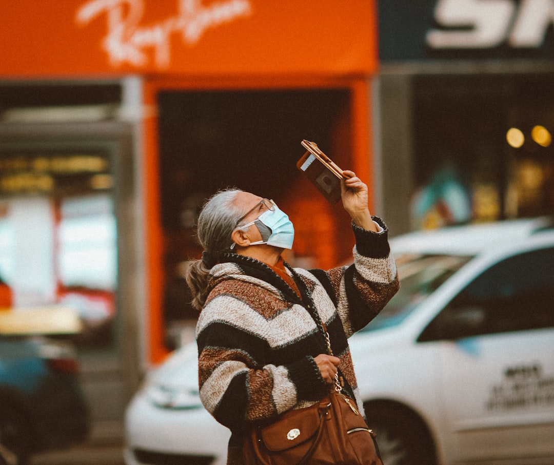 woman in brown coat holding smartphone