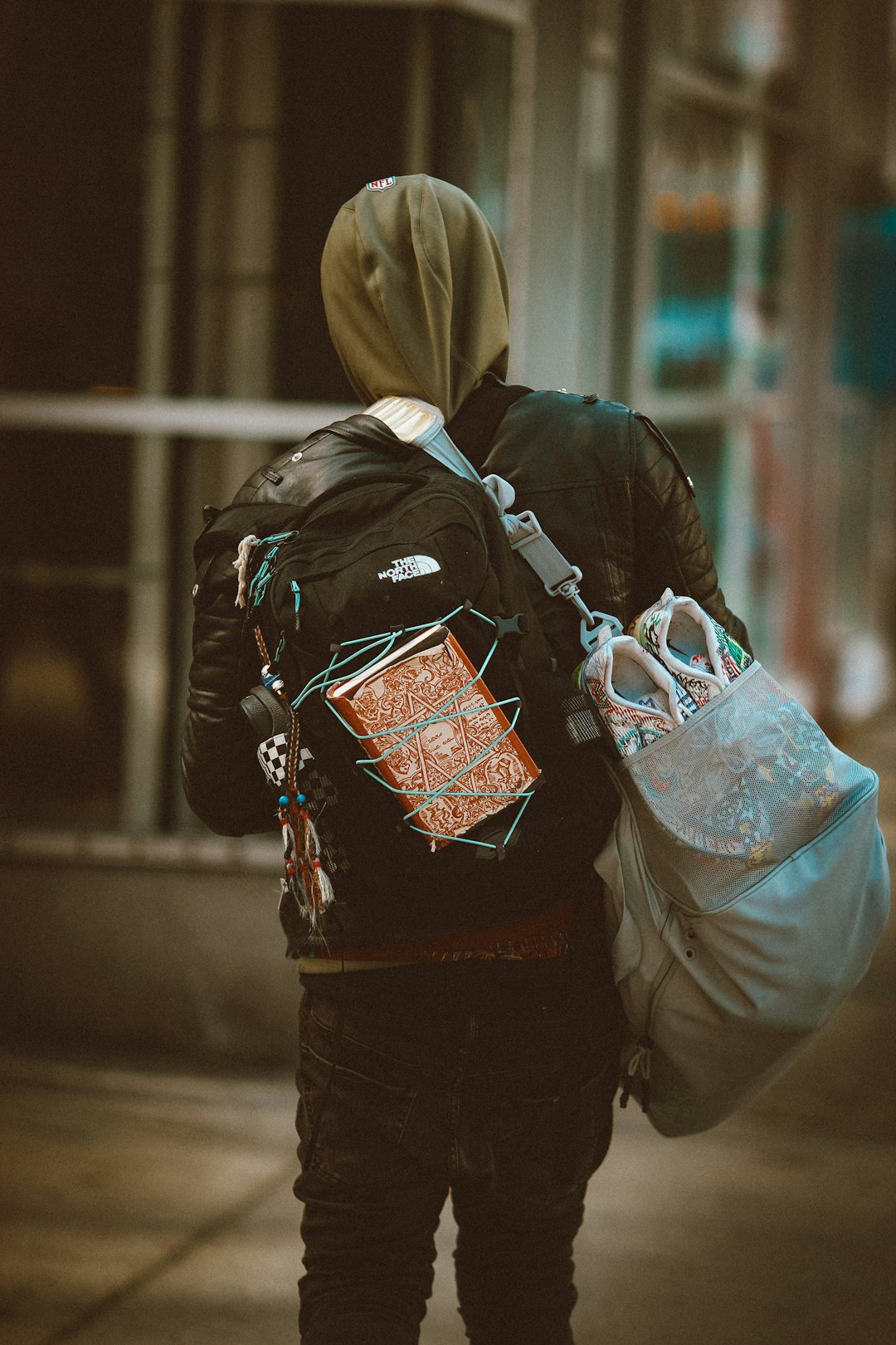 person in black jacket carrying brown leather sling bag