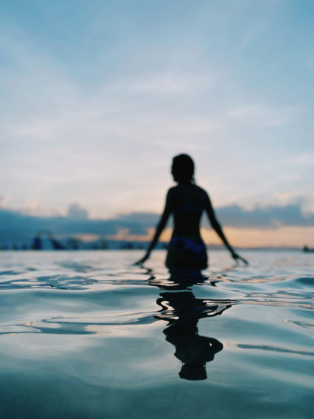 woman in black bikini standing on water during daytime