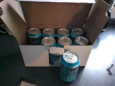 Hands holding a Red Dog brew kit box with ingredients and instructions visible.