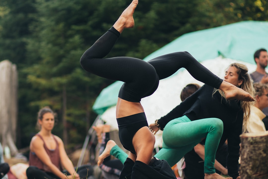 woman in black leggings and black sports bra doing yoga during daytime