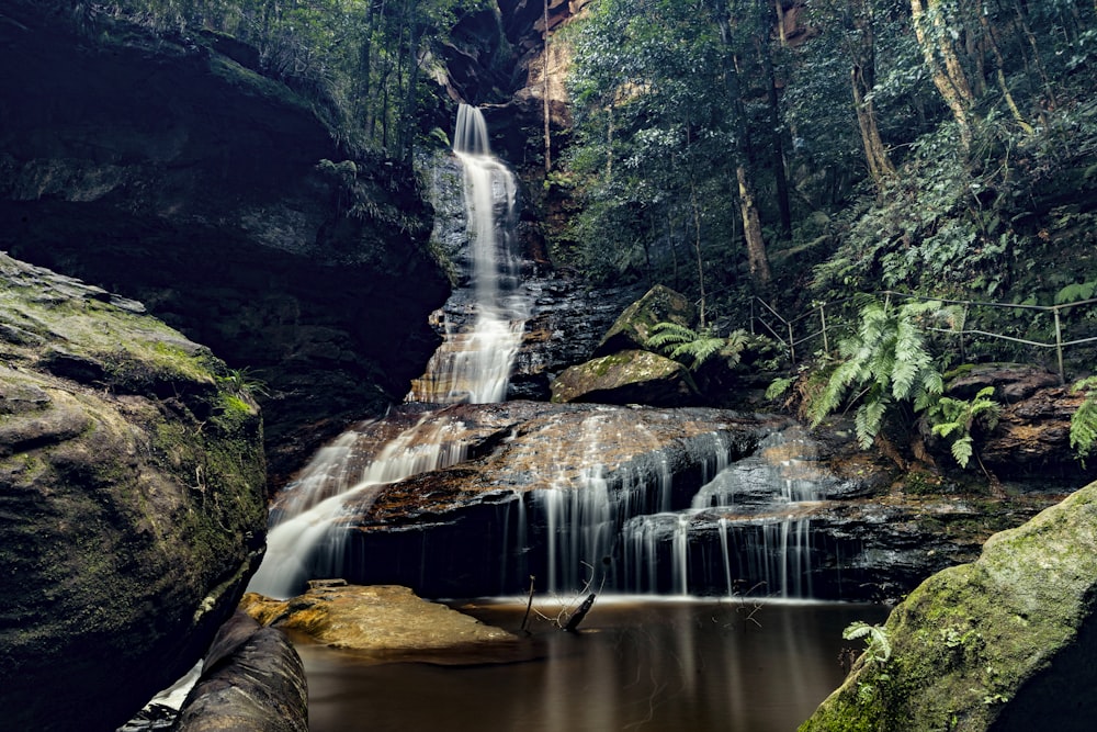 waterfalls in the middle of the forest during daytime