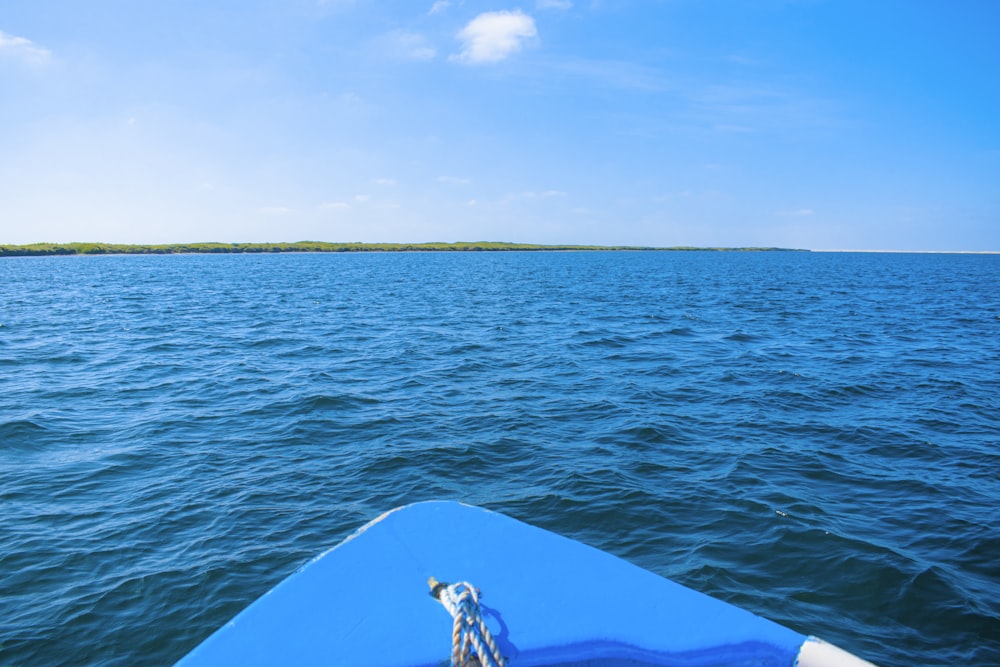 blue and white boat on blue sea under blue sky during daytime