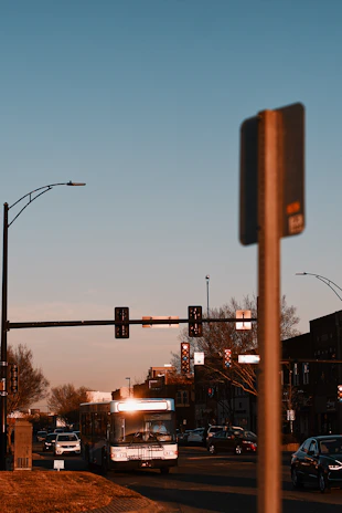 A cityscape at dusk with buses and shared vehicles moving smoothly, highlighting connected transit.