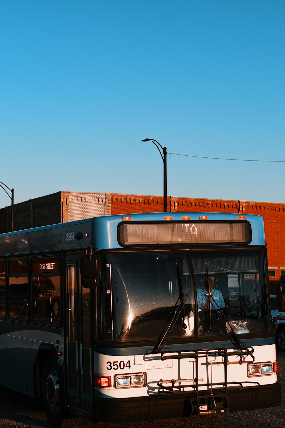 낮 동안 도로에서 파란색과 흰색 버스