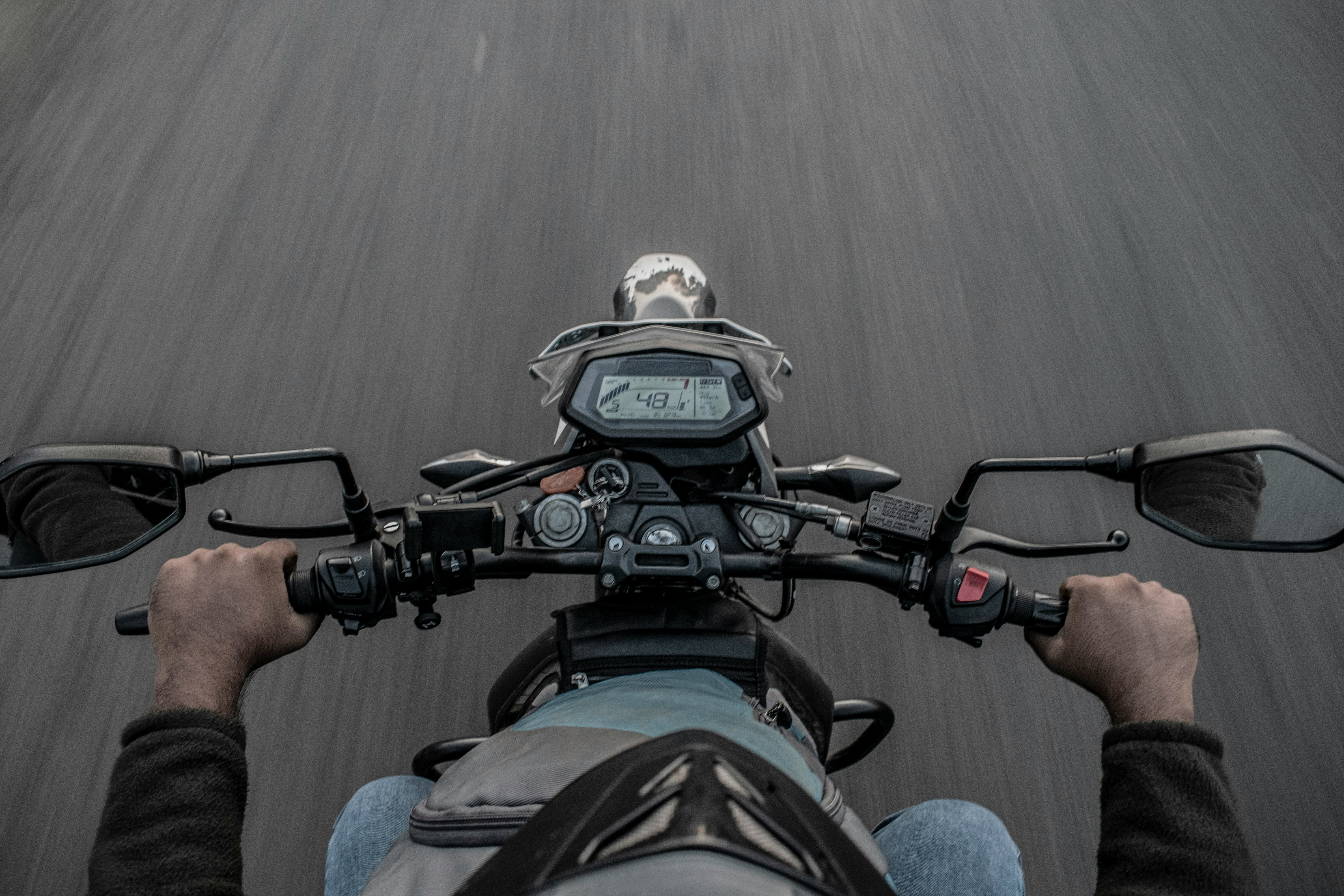 person in blue denim jeans riding motorcycle during daytime