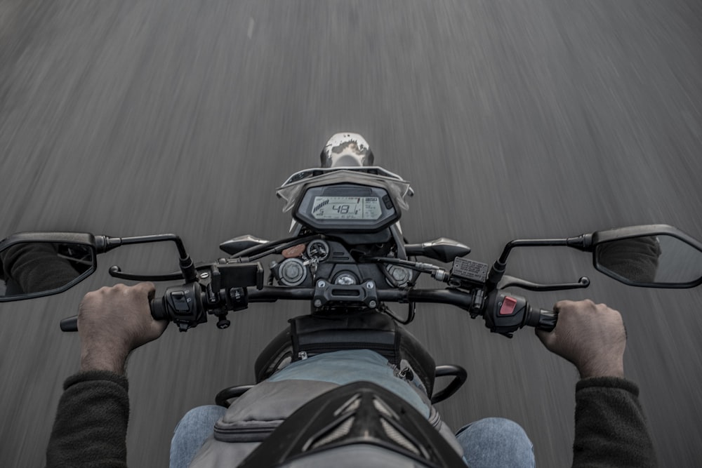 person in blue denim jeans riding motorcycle during daytime