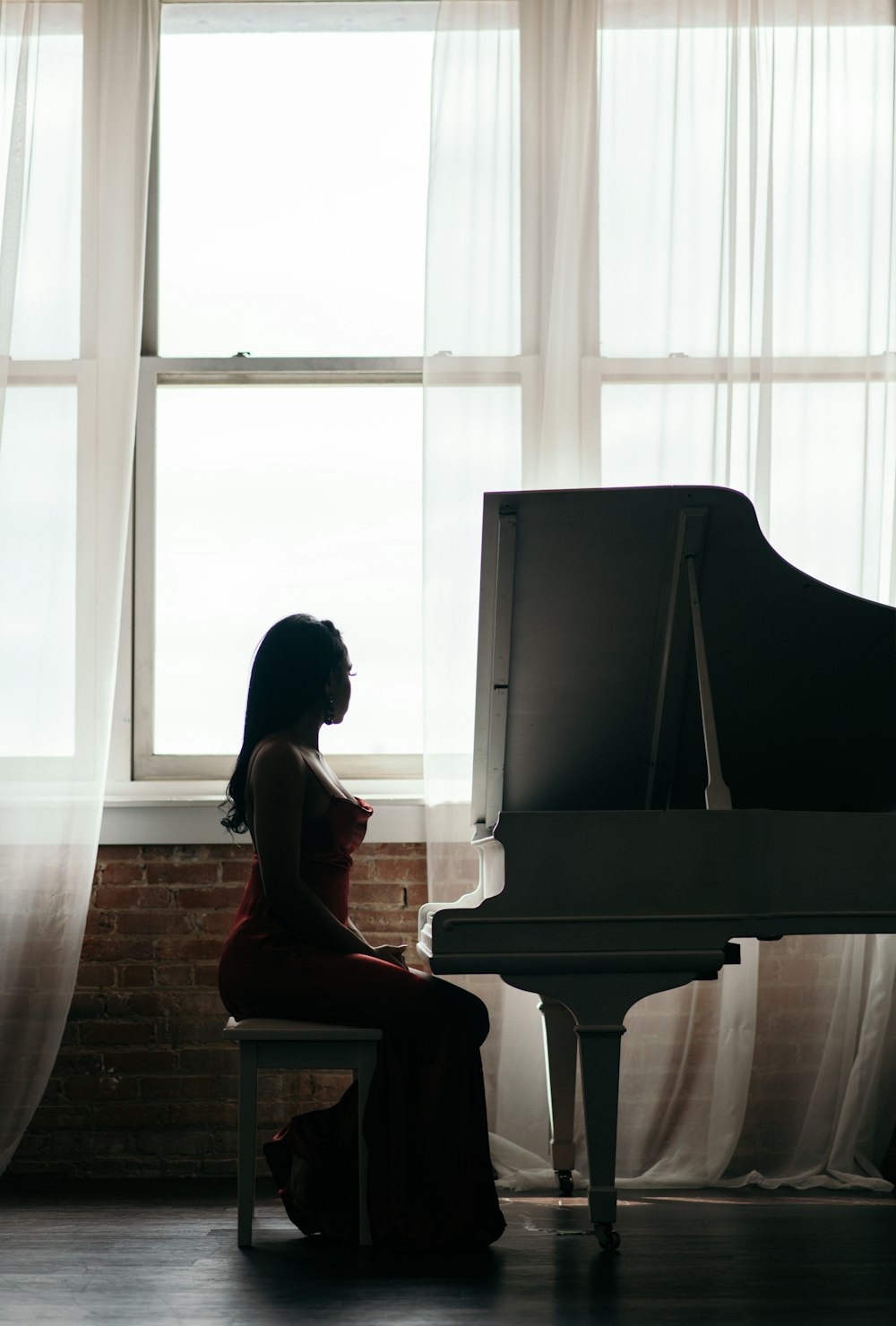 donna seduta sulla sedia vicino al pianoforte a coda