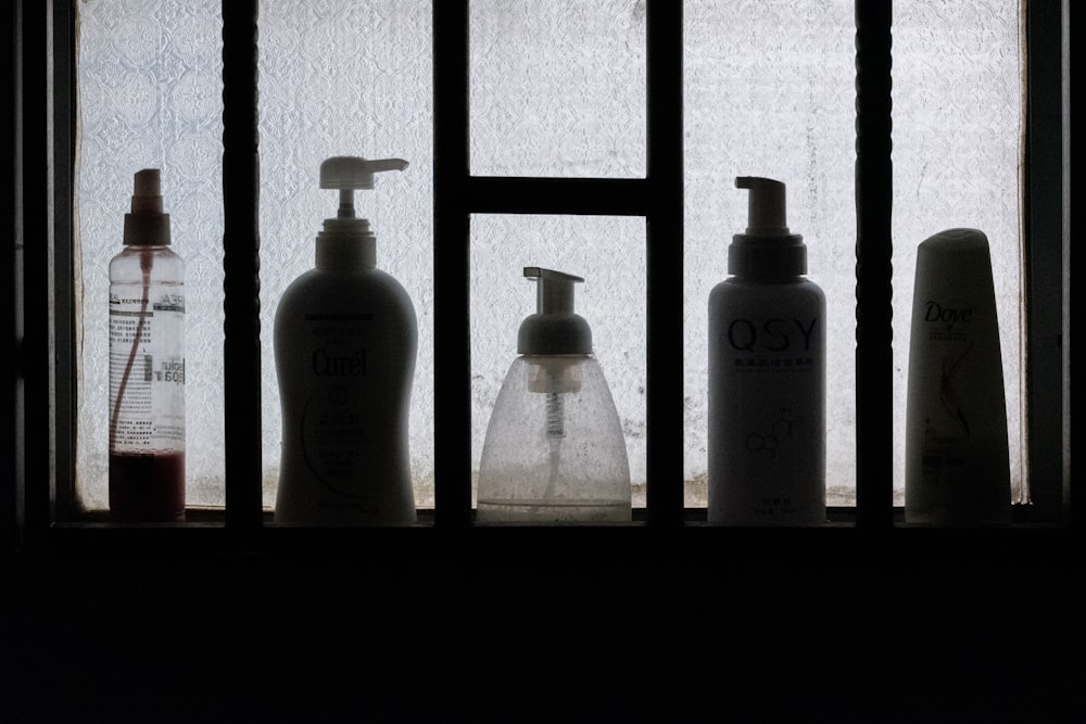 3 bottles on black wooden shelf