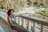 A relaxed person enjoying a quiet morning vape on a sunlit balcony.
