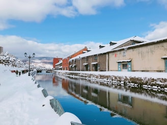 brown and white concrete building near body of water under blue sky during daytime