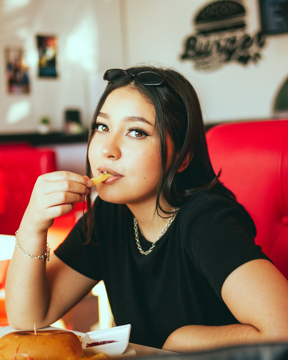 woman in black t-shirt sitting on red couch