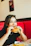 A smiling customer enjoying a juicy burger at a vibrant fast food restaurant.