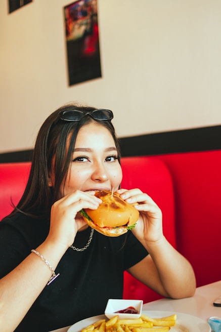Children laughing and enjoying dinosaur-themed burgers with colorful plates.