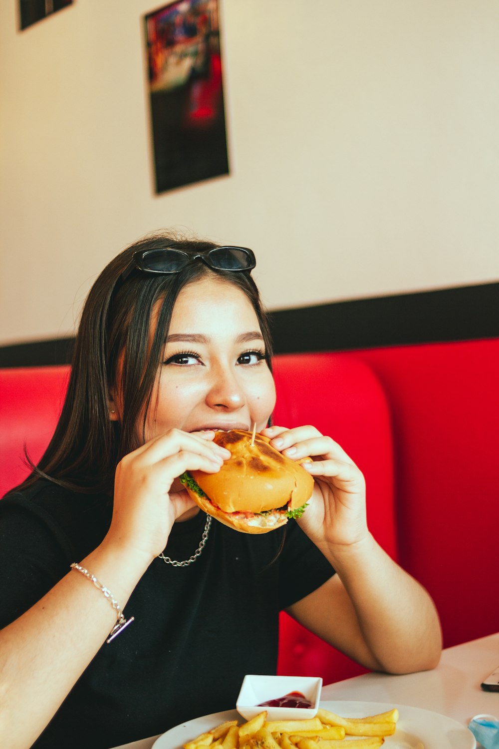 woman in black long sleeve shirt eating burger