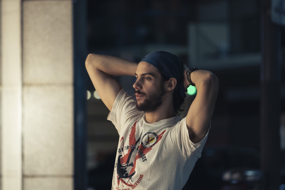 homme en t-shirt blanc à col rond portant une casquette bleue