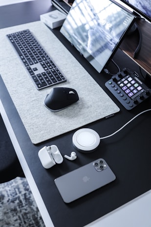A modern desk setup featuring a wireless charging station and minimalist organization tools.