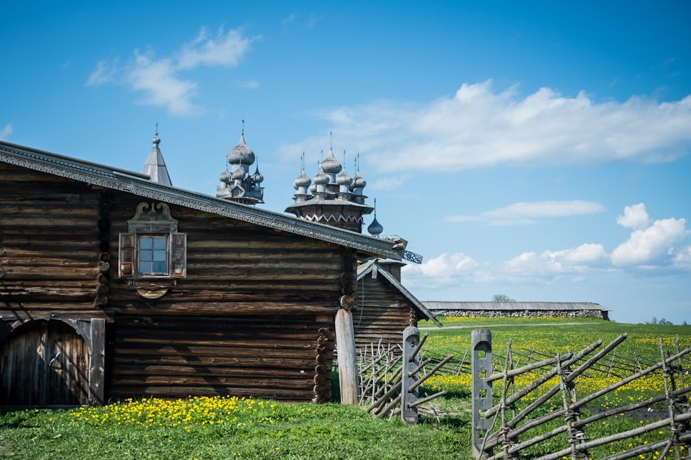 brown wooden house on green grass field under blue sky during daytime