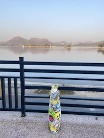 A sleek cruising longboard resting against a graffiti-covered wall.