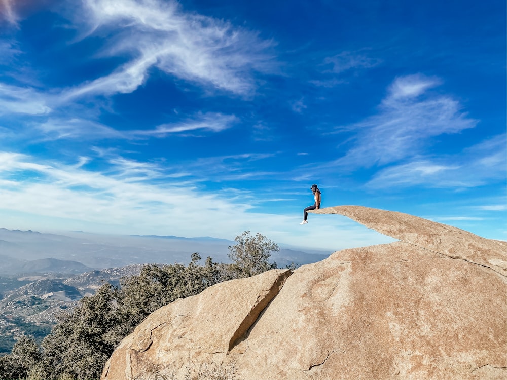 person standing on brown rock under blue sky during daytime