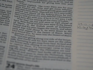 Close-up of a student writing detailed notes from a textbook.