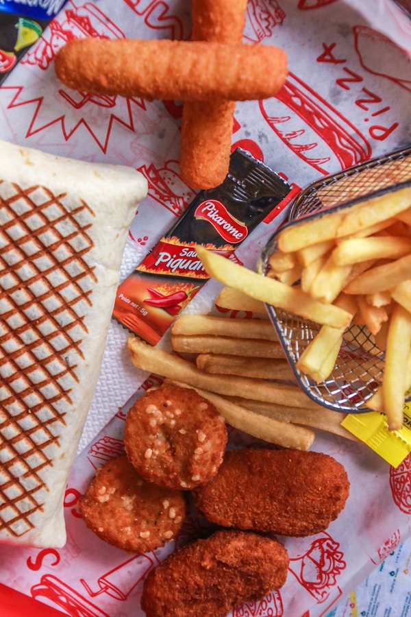 French fries and fried meat on white paper plate