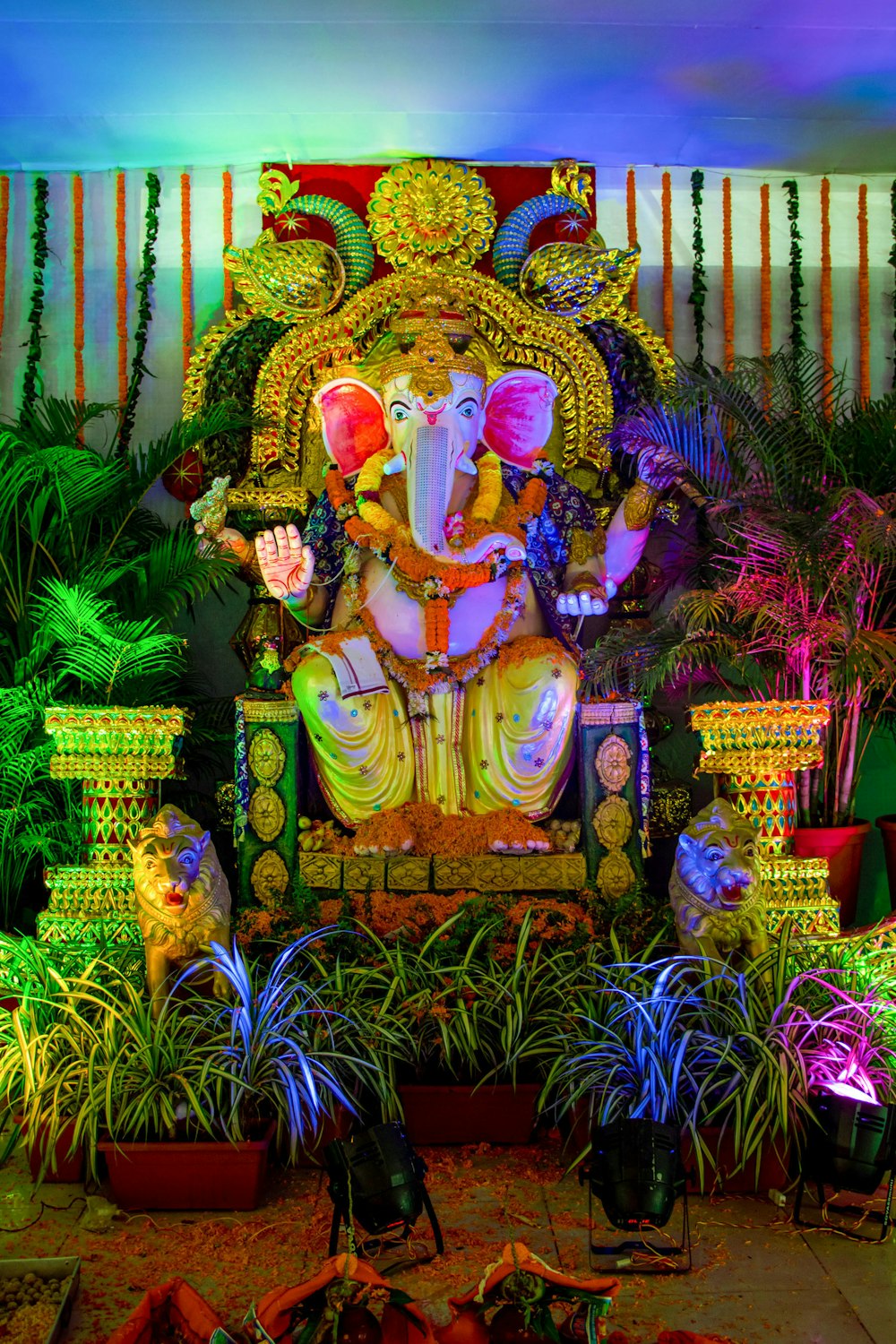 Estatua de la deidad hindú rodeada de plantas verdes
