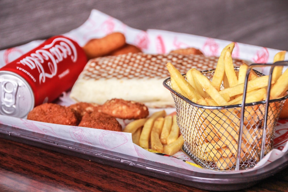 fries and coca cola can on tray