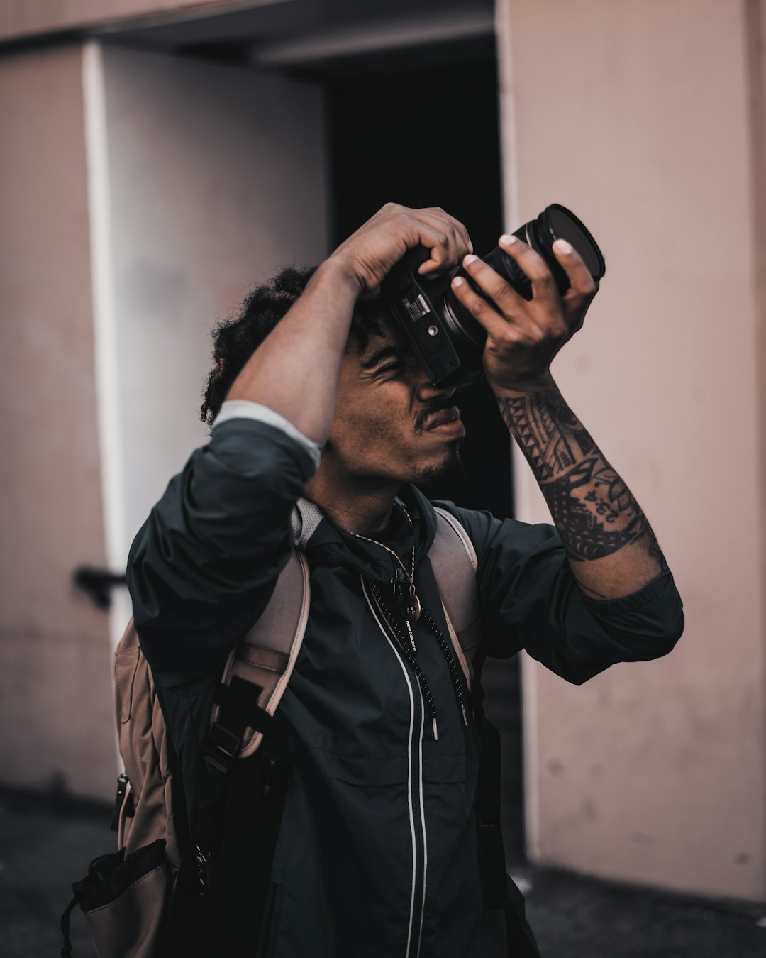 man in black jacket holding black dslr camera