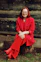 woman in red blazer and black skirt sitting on brown concrete stairs