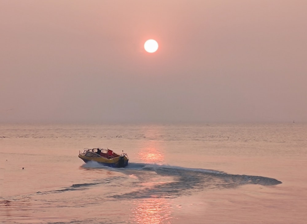 man riding on orange and white boat on sea during sunset