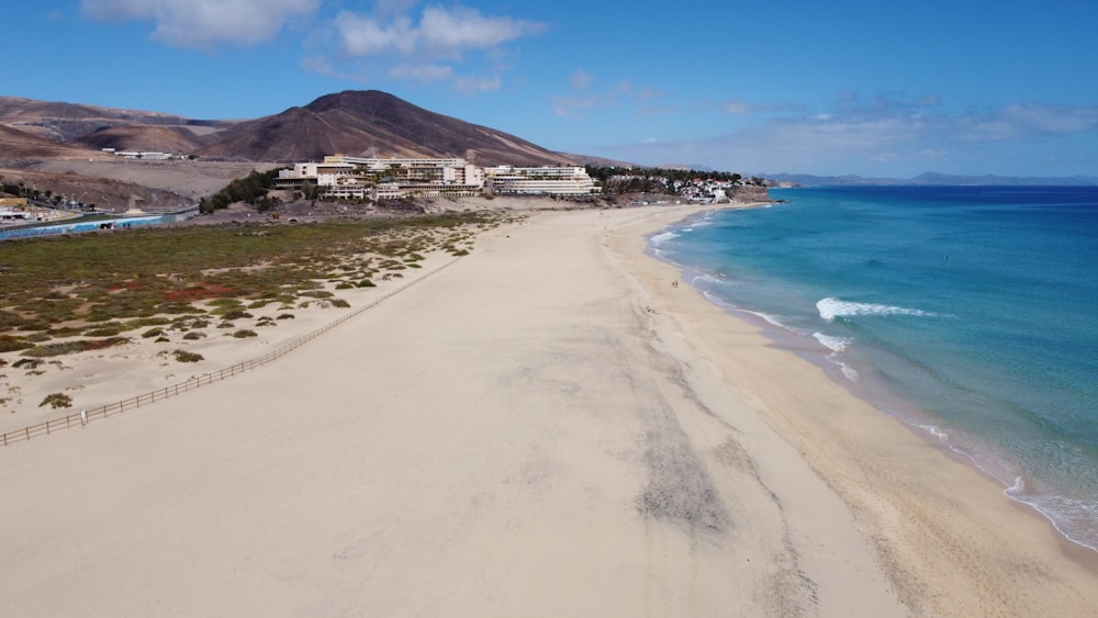 white sand beach near mountain under blue sky during daytime