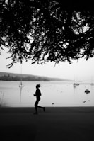 man in black jacket and pants standing on shore near body of water during daytime