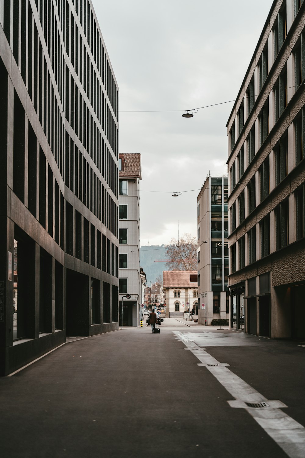 people walking on sidewalk between high rise buildings during daytime