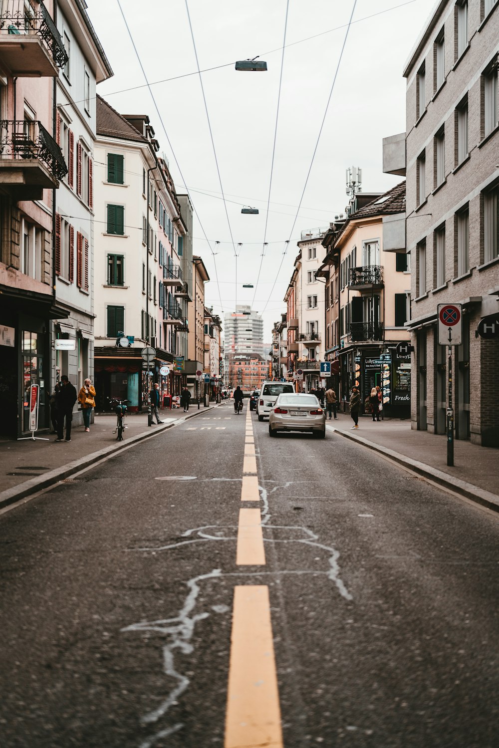 auto parcheggiate sul ciglio della strada tra gli edifici durante il giorno