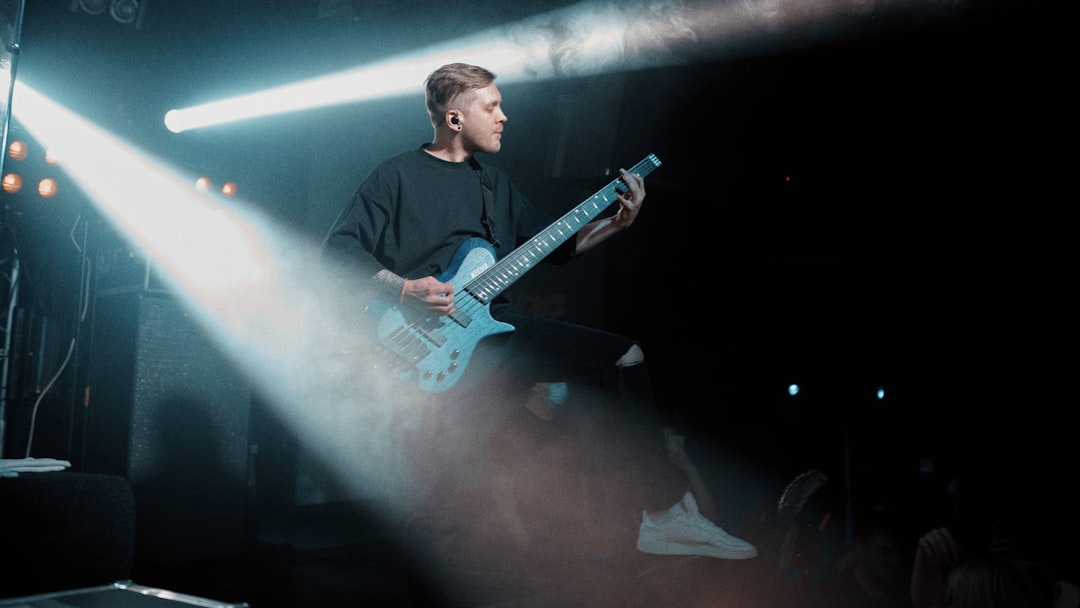 man in black jacket playing electric guitar