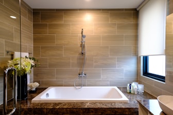 white ceramic bathtub with stainless steel faucet