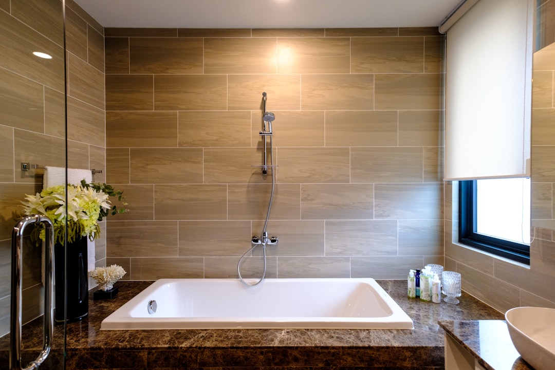 white ceramic bathtub with stainless steel faucet