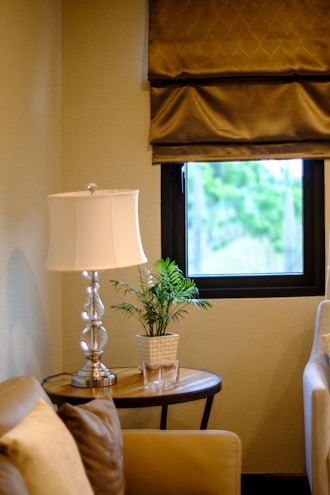 A cozy living room corner featuring a stylish lamp and elegant side table from debonair furnishings.