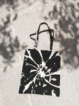 A stylish tote bag featuring a bold, artistic print resting on a sunlit table.