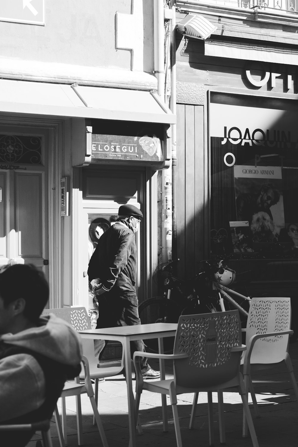 grayscale photo of man sitting on chair