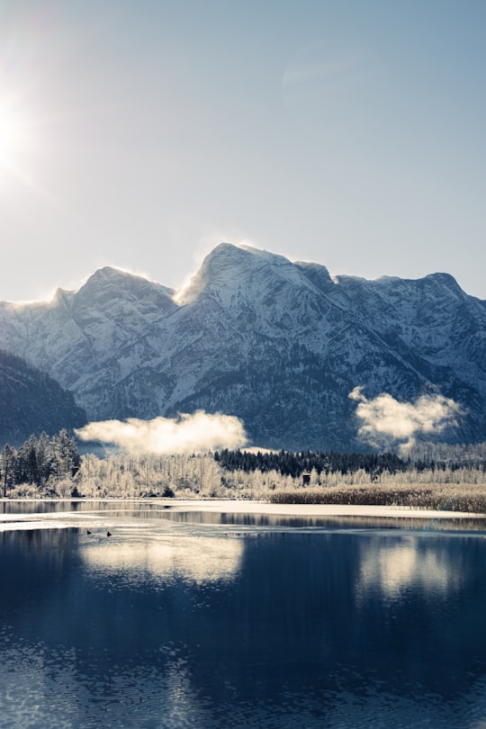 snow covered mountain near body of water during daytime in Almsee Austria