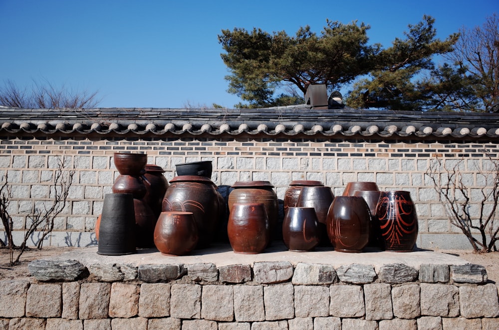 brown clay pots on brown brick wall