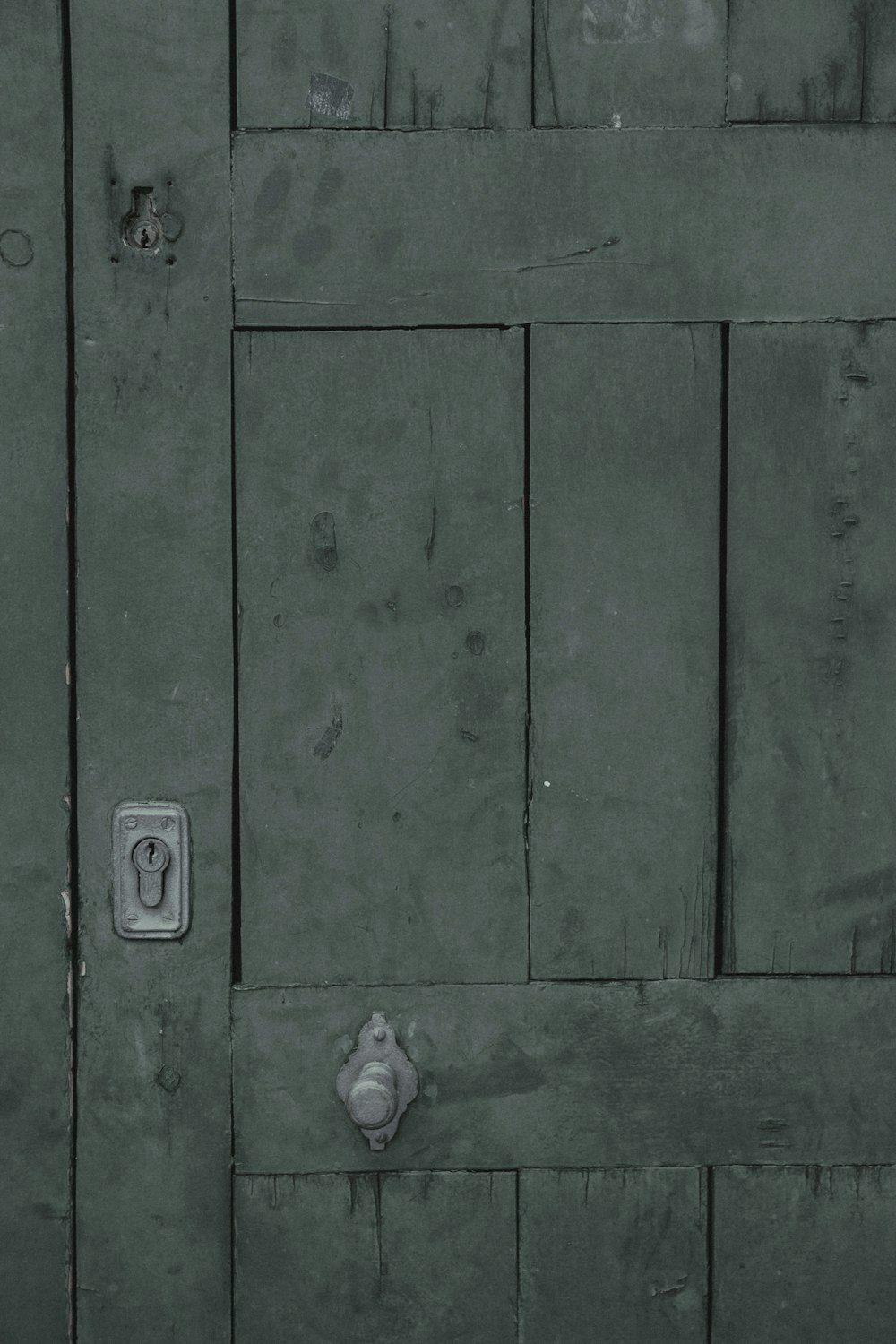 green wooden door with gray steel door knob