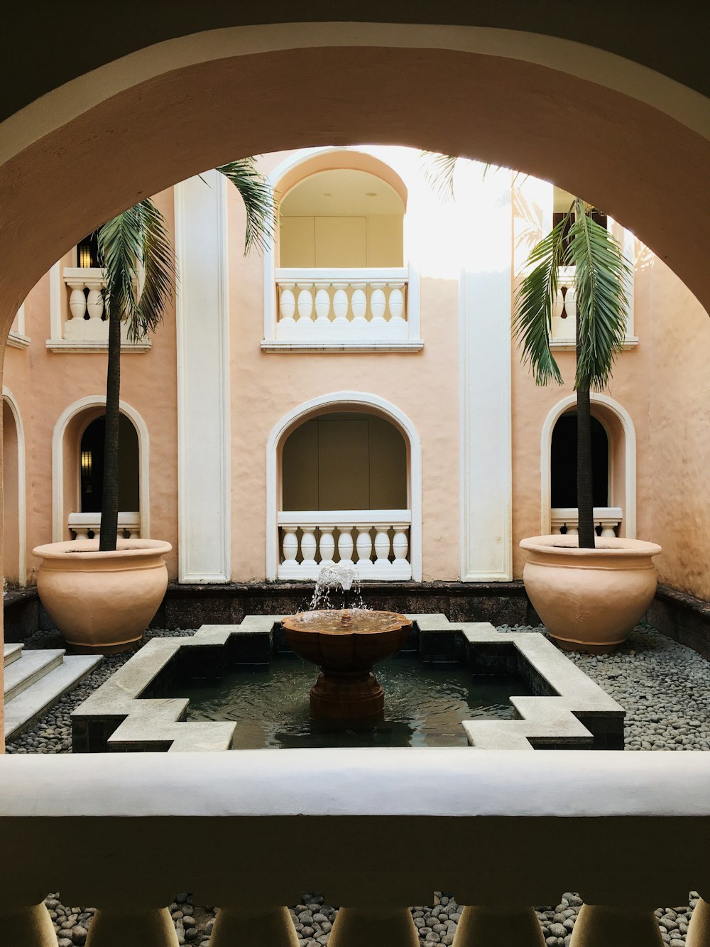 brown concrete fountain in front of white concrete building